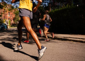 three runners round a street corner