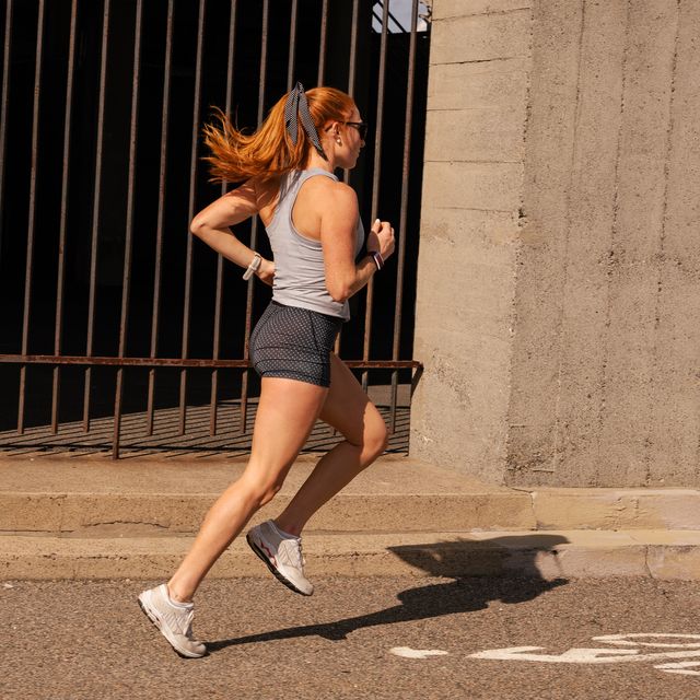 woman running past a cement wall