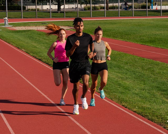 three runners doing a speed workout on a track