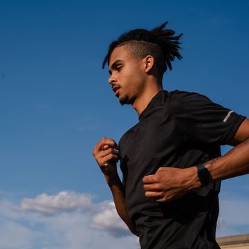 man running with a blue sky in the background