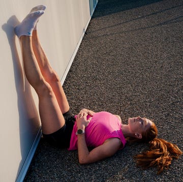Person performing a wall assisted leg stretch person performing a wall assisted leg stretch