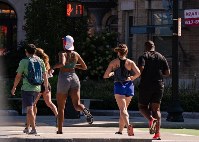 group of runners passing a street countdown timer