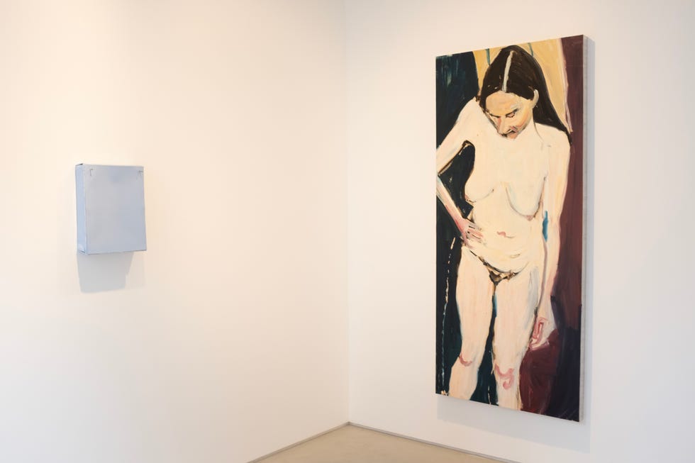 contemporary art installation featuring a nude female figure painting with a cutout area for interaction