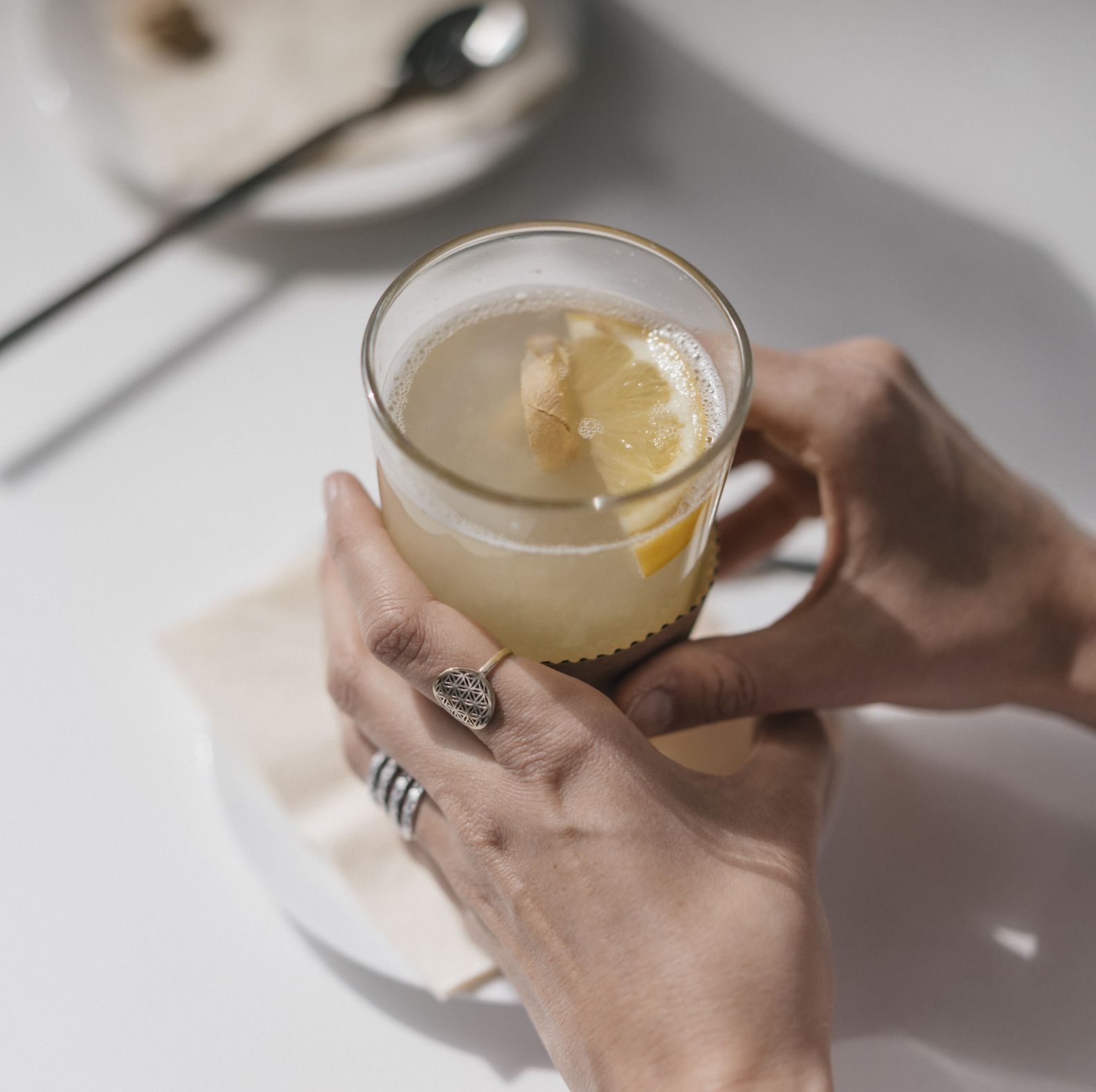 woman holding glass of ginger lemon tea