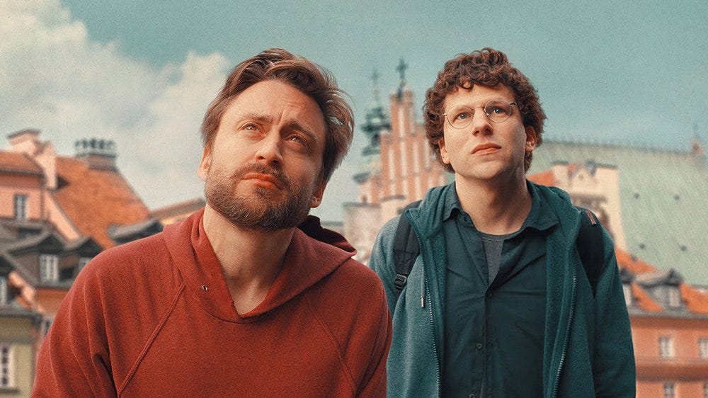 two individuals standing in front of a historic cityscape
