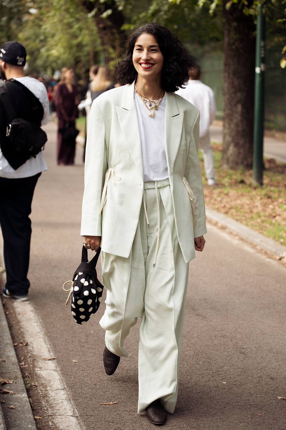 Milan, Italie, 20 septembre : une invitée porte une chemise blanche, un blazer et un pantalon vert menthe et un sac noir à pois blancs lors du défilé Gucci lors de la Fashion Week de Milan printemps/été 2025, le 20 septembre 2024 à Milan, en Italie. (Photo de Raimonda Kulikauskiene/Getty Images)