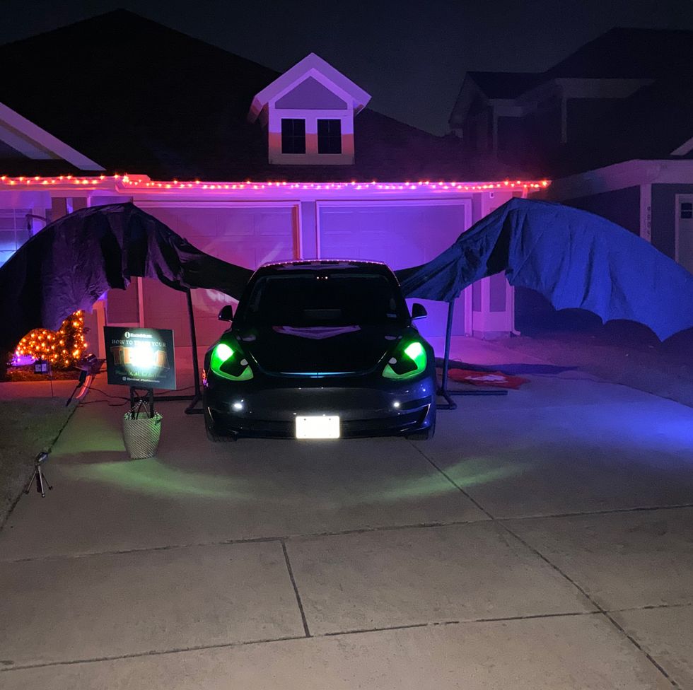 a car decked out for trunk or treat in a how to train your dragon theme looking like toothless at night
