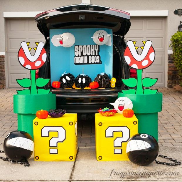 a car decked out for trunk or treat in a super mario bros theme with chain chomps, question boxes, piraña plants and more