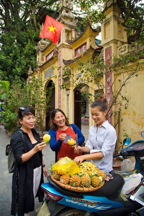 V Thu Phuong rechts in beeld Ly Quoc Su een van de oudste tempels van Hanoi per dag verkoopt ze ongeveer 70 vruchten Wat ik het leukst vind van dit werk is buitenlanders te ontmoeten en te spreken zegt ze