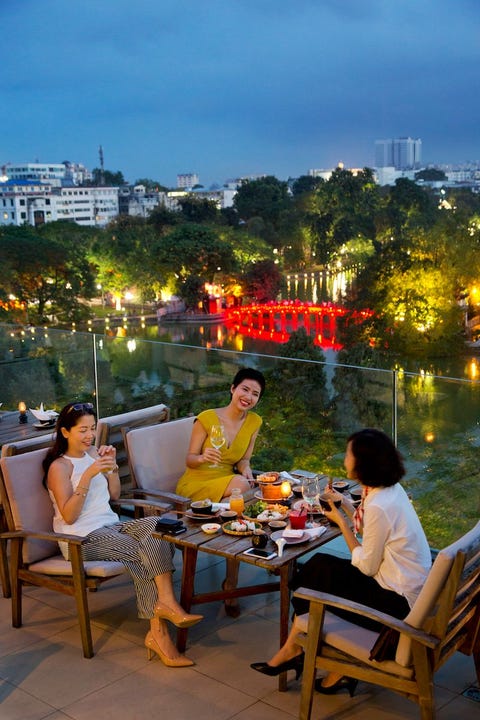 Restaurant Cau Go dat letterlijk houten brug betekent biedt een spectaculair uitzicht over het Hon kimmeer in het centrum van Hanoi dat ook wel het Meer van het Zwaard wordt genoemd Hanoianen komen er graag voor een drankje en maaltijd na hun werk