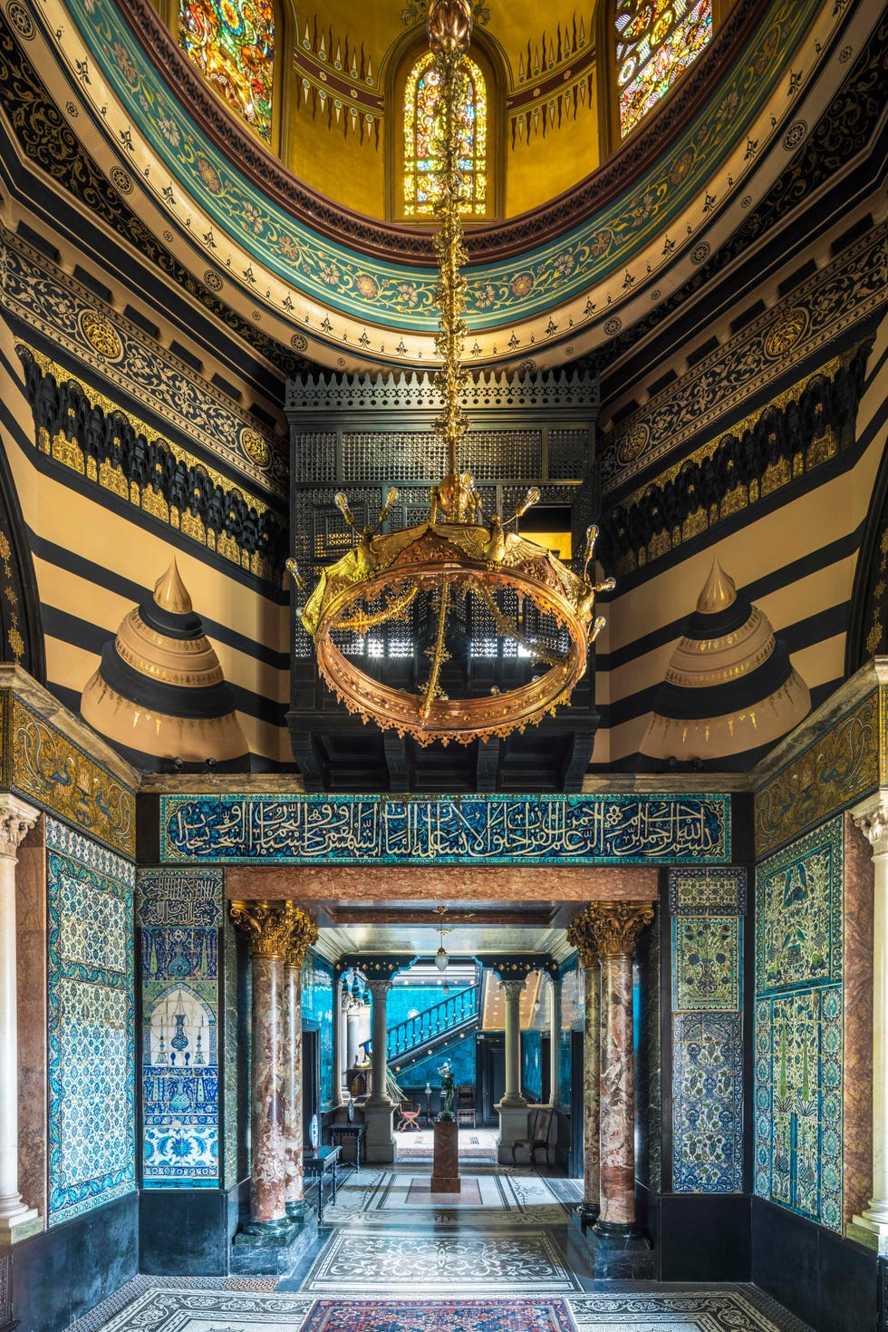 Opulent interior space featuring intricate tile work and a grand chandelier.