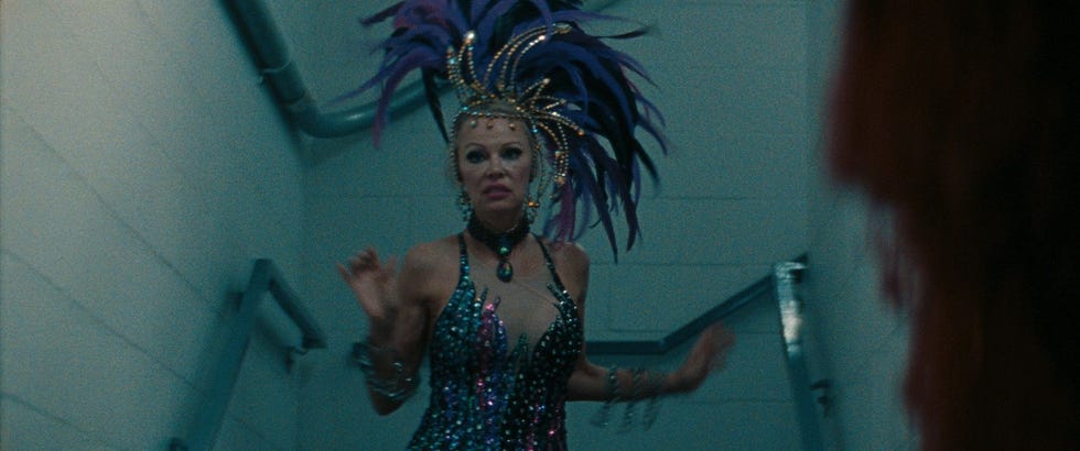 A performer in an elaborate costume descends a staircase