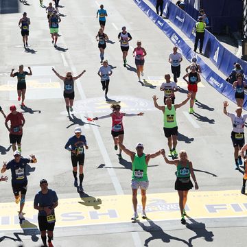 boston qualifying marathons a group of runners raise their hands at the finish line of the boston marathon