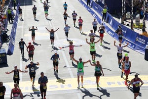 boston qualifying marathons a group of runners raise their hands at the finish line of the boston marathon