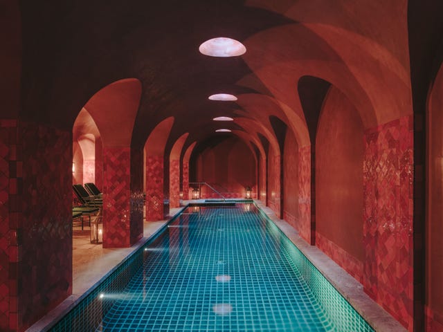 Indoor swimming pool with arched architecture and ambient lighting.