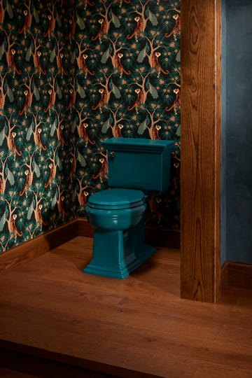 vintagestyle teal toilet in a room with decorative wallpaper