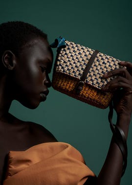 a beautiful model holding a straw bag