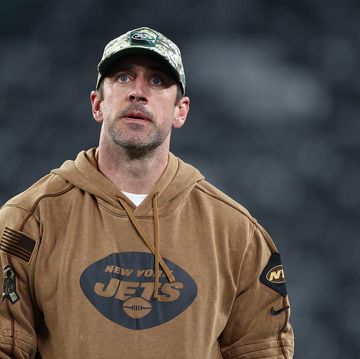 aaron rodgers wearing a camouflage hat and looking upward