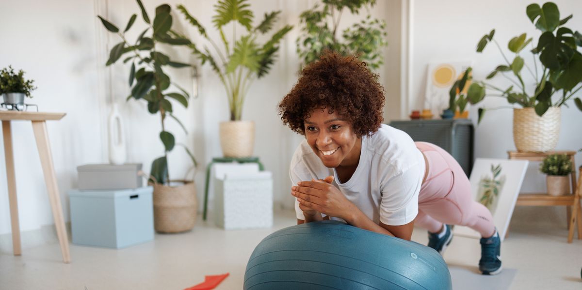 woman using exercise ball to plank at home