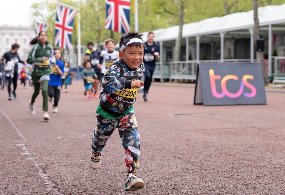 a small, smiling child running along the mall in london