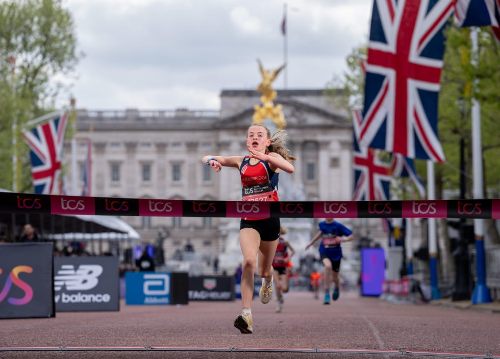 girl breaks the finish line tape and wins the mini london marathon on the mall