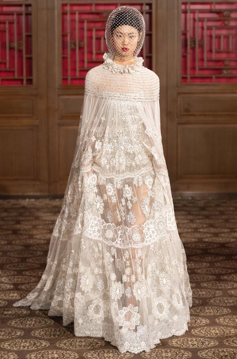 Sognare l'abito da sposa non fa mai male: alla moda uomo parigina alla sfilata Valentino la cantante Fka Twigs ha cantano live con un vestito lungo bianco magico.