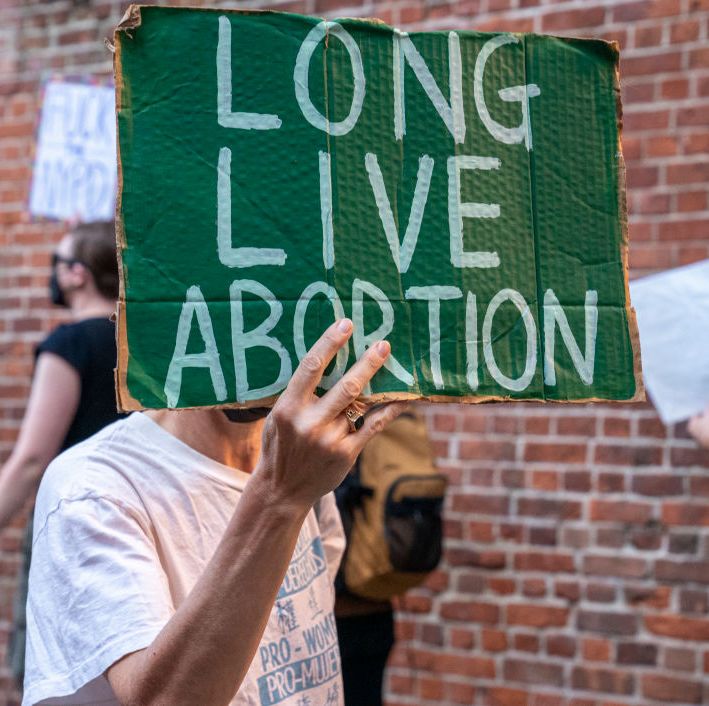 protester holding a sign that reads long live abortion