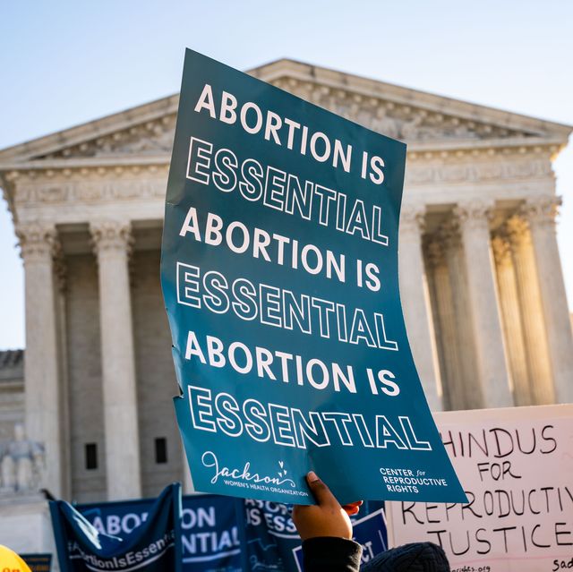someone holding a sign in front of the supreme court that says abortion is essential