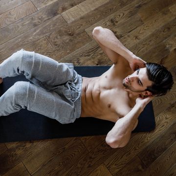 above view of athletic man exercising sit ups on exercise mat