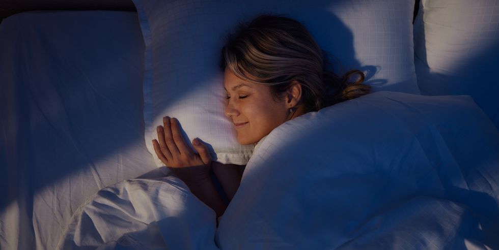 above view of smiling woman sleeping in bed