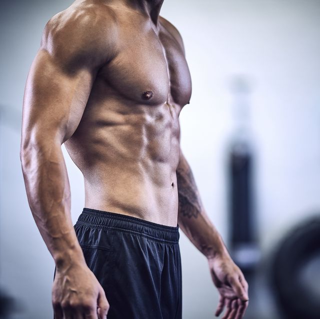 torso of muscular male bodybuilder in industrial gym