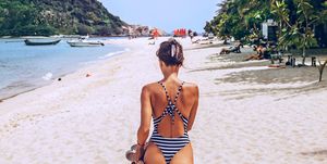 woman walking on a beach in a thong