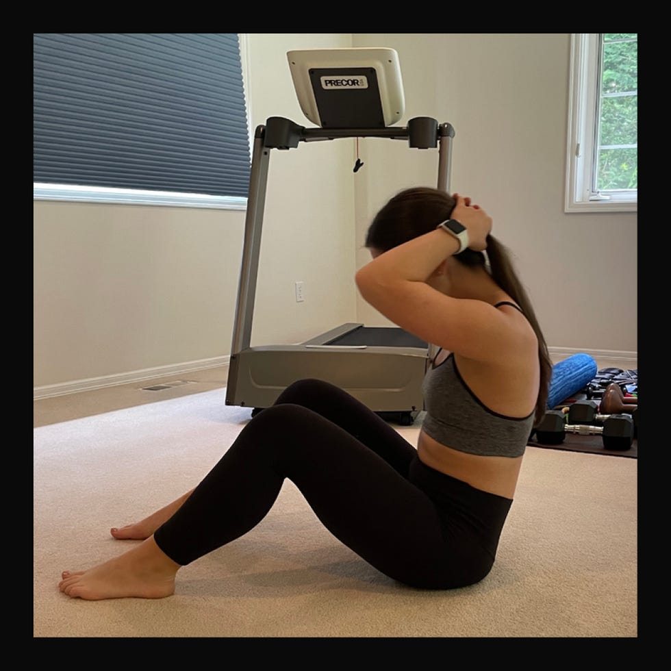 woman performing situps in a home workout setting