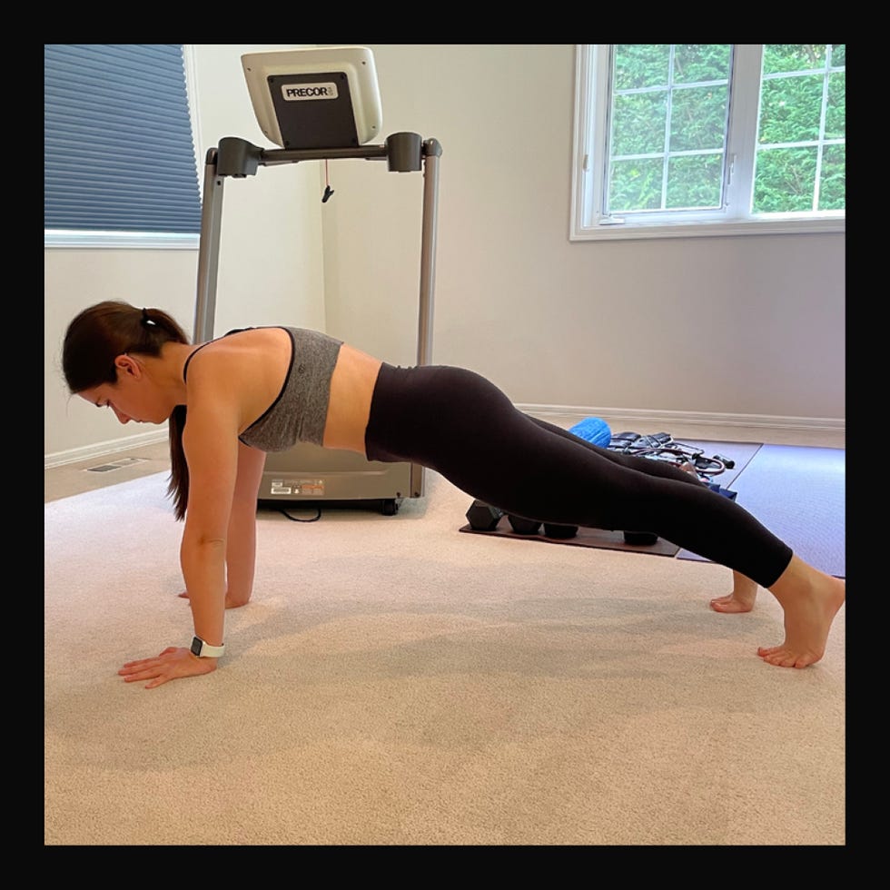 person performing a plank exercise in a home gym setting