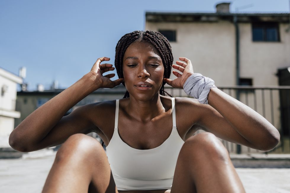 portrait of young woman in white shirt doing sits up during fitness warming up