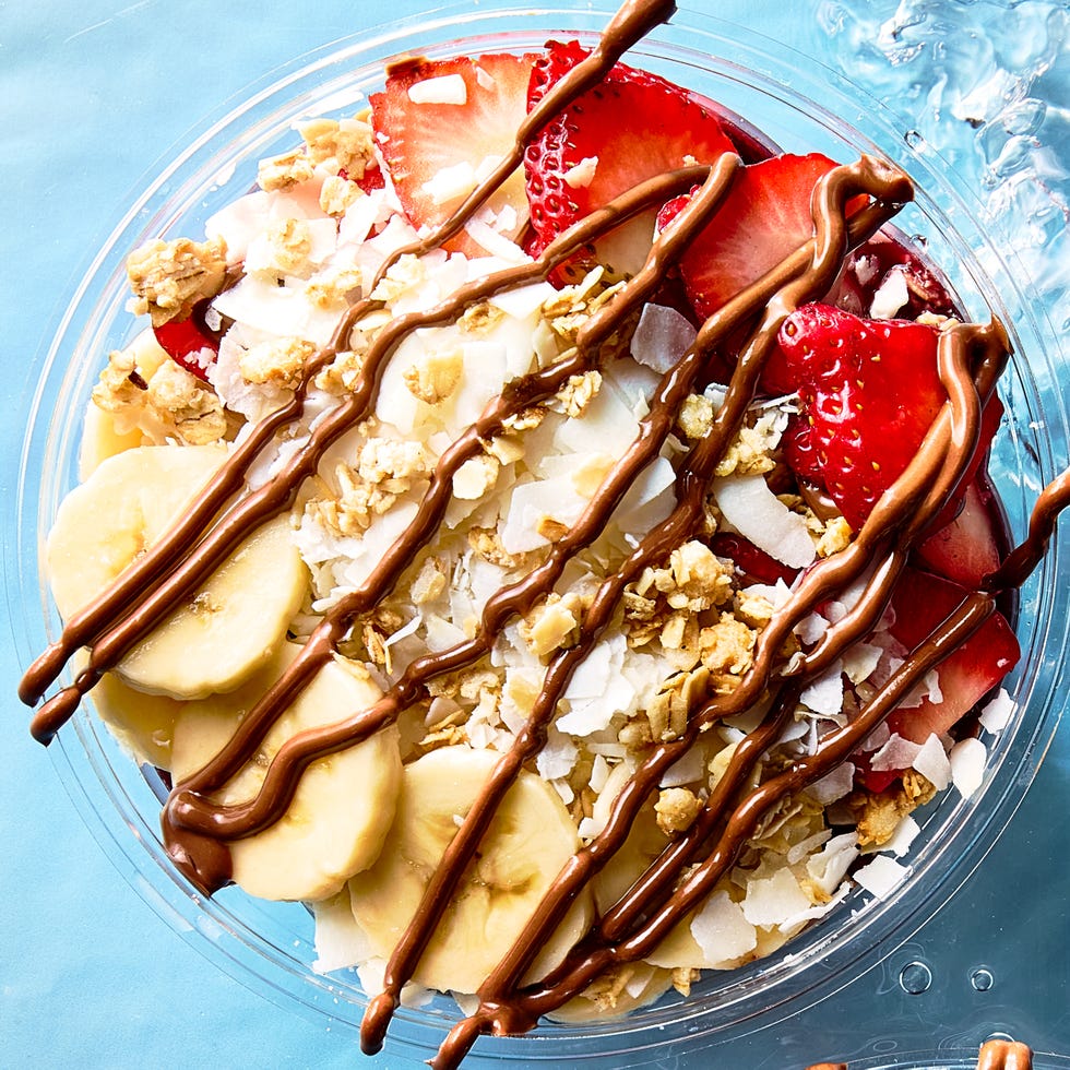 acai playa bowl topped with bananas, strawberries, coconut shreds, and granola