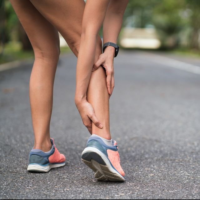 walking pain achilles injury on running outdoors women holding achilles tendon by hands close up and suffering with pain ankle twist sprain accident in sport exercise running jogging