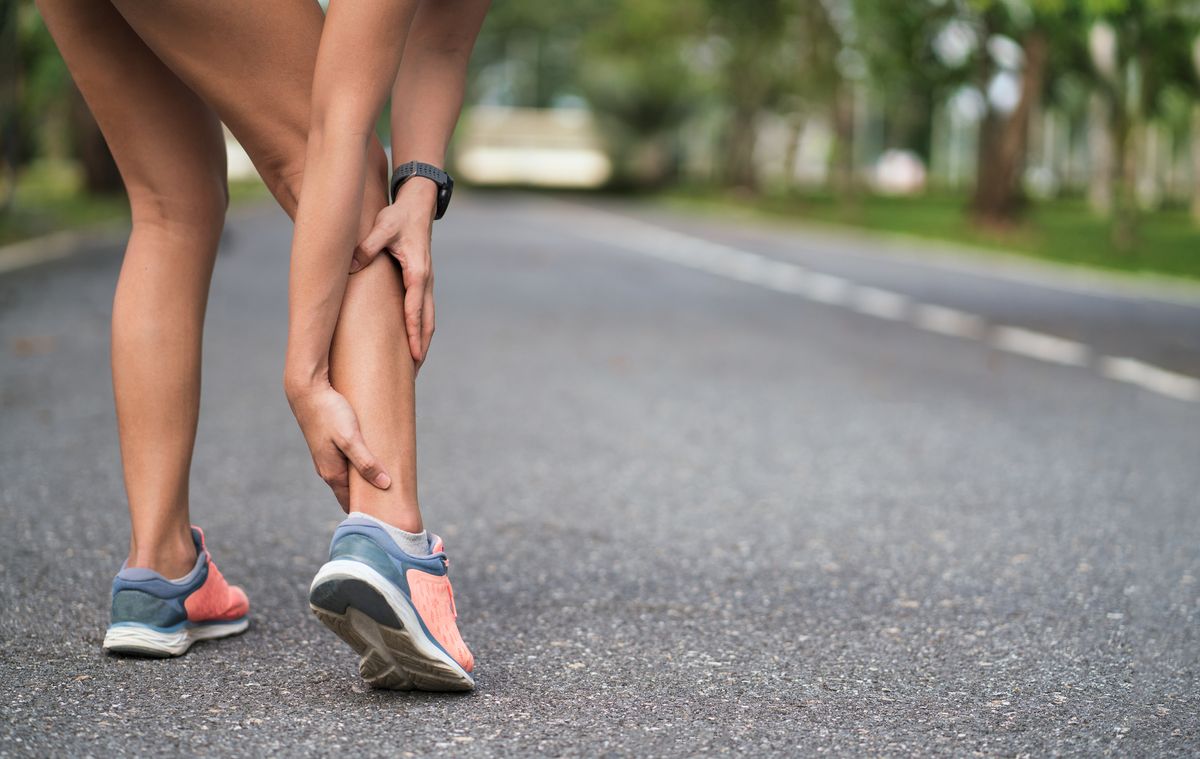 walking pain achilles injury on running outdoors women holding achilles tendon by hands close up and suffering with pain ankle twist sprain accident in sport exercise running jogging