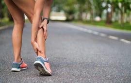 achilles injury on running outdoors women holding achilles tendon by hands close up and suffering with pain ankle twist sprain accident in sport exercise running jogging