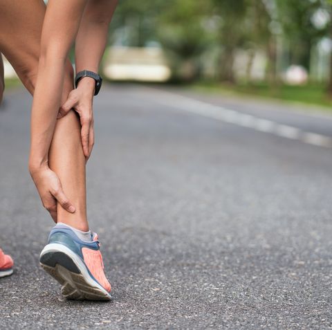 achilles injury on running outdoors women holding achilles tendon by hands close up and suffering with pain ankle twist sprain accident in sport exercise running jogging