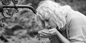 germany out eighties, black and white photo, people, young woman drinking water from a spring, refreshment, cooling, portrait, blond, 30 to 35 years, elizabeth photo by werner otto\ullstein bild via getty images
