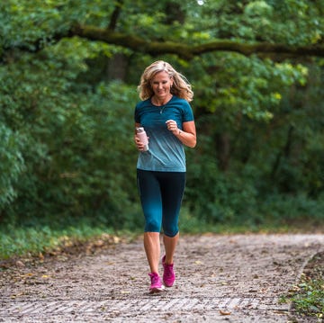 Active Mature Caucasian Woman Running In The Forest active mature caucasian woman running in the forest