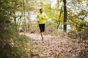 active mature man running in forest