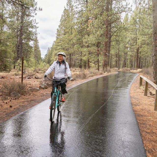 biking in the rain active mixed race senior woman on relaxing bike ride