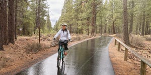 biking in the rain active mixed race senior woman on relaxing bike ride