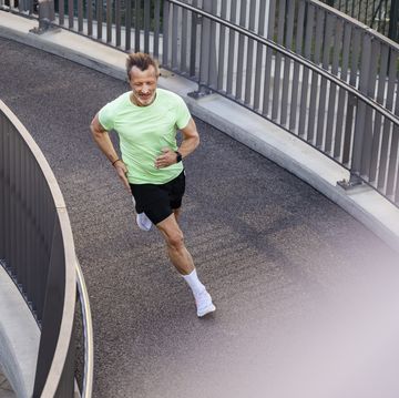 active sportsman jogging on footbridge