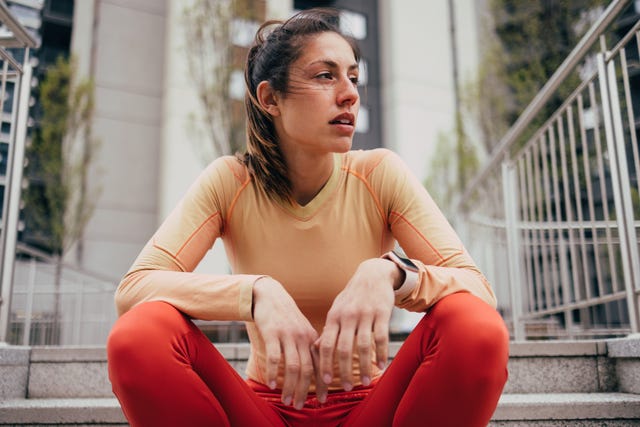 active woman in sportswear taking a break on stairs outdoors