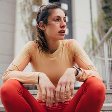 Active Woman in Sportswear Taking a Break on Stairs Outdoors active woman in sportswear taking a break on stairs outdoors