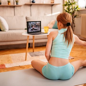 active woman watching online video training on laptop