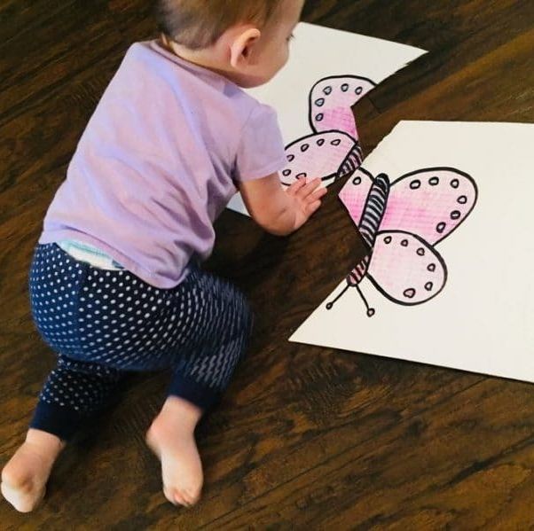 a toddler puts together a giant cardboard two piece puzzle